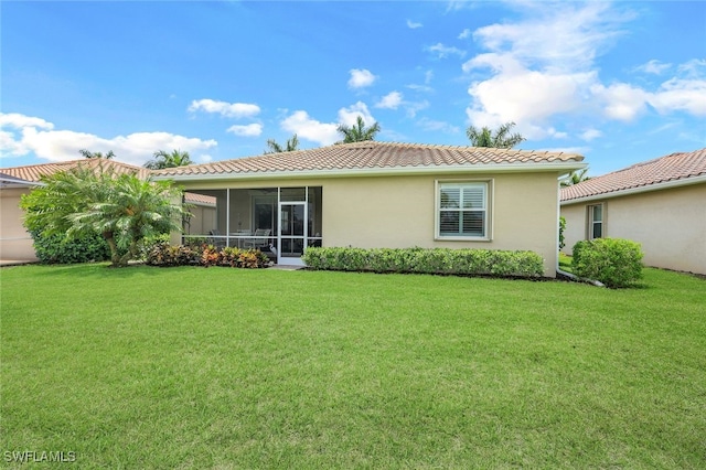 back of property featuring a lawn and a sunroom