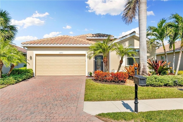 mediterranean / spanish-style home with a front yard and a garage