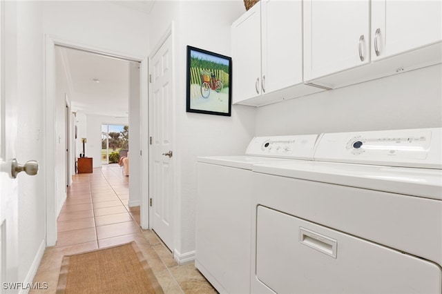 washroom featuring cabinets, washer and dryer, and light tile patterned floors