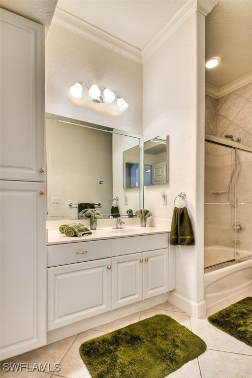 bathroom featuring tile patterned floors, vanity, ornamental molding, and combined bath / shower with glass door