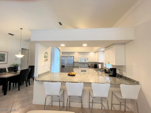 kitchen with sink, white cabinets, kitchen peninsula, white appliances, and light tile patterned floors