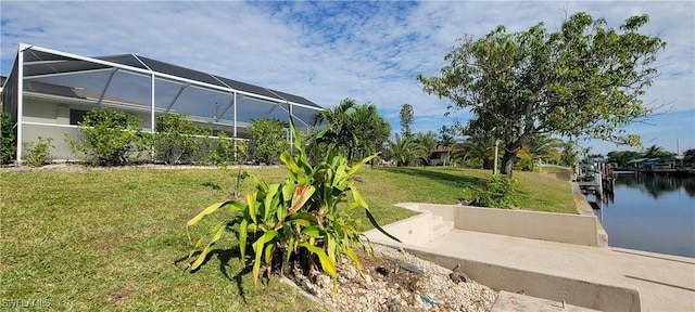 view of yard featuring a lanai, a water view, and a dock