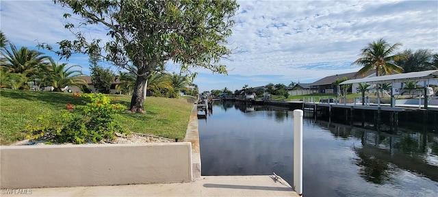 dock area with a water view and a lawn