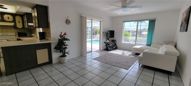 living room featuring ceiling fan, light tile patterned floors, and sink