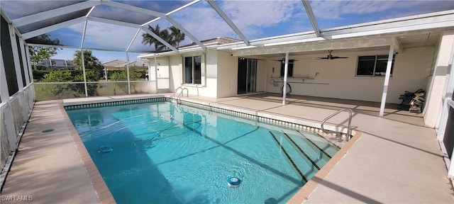 view of swimming pool featuring glass enclosure, ceiling fan, and a patio area