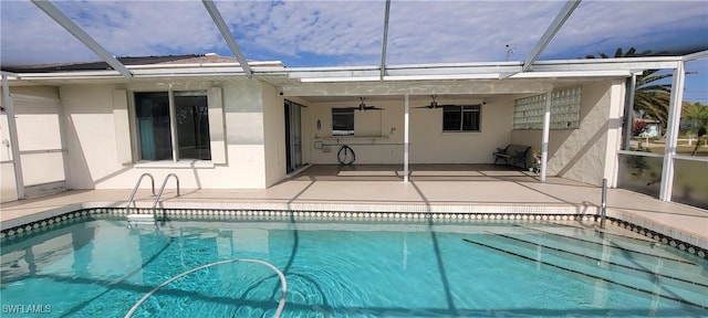 view of pool with a lanai, ceiling fan, and a patio