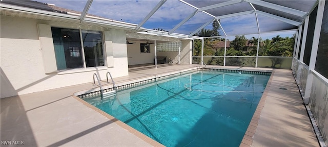 view of pool with glass enclosure and a patio