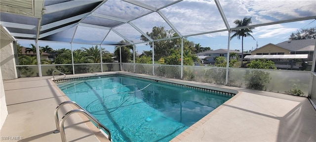 view of swimming pool with glass enclosure and a patio area