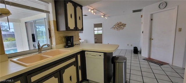 kitchen with dishwasher, kitchen peninsula, light tile patterned flooring, and sink