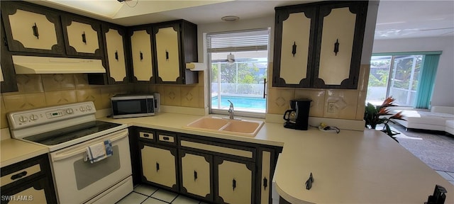 kitchen featuring tasteful backsplash, sink, light tile patterned floors, and white electric range