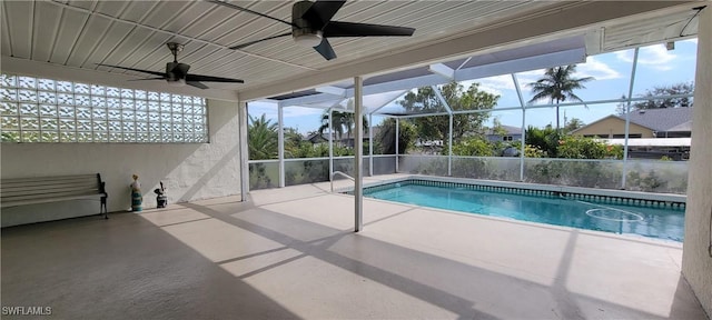 view of pool with glass enclosure, ceiling fan, and a patio