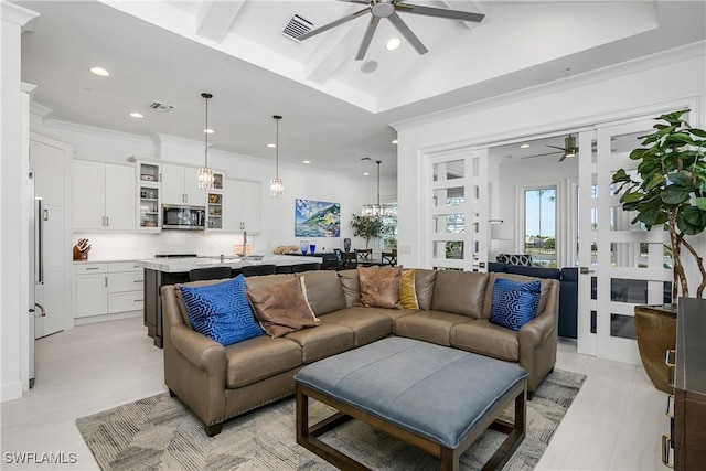 living room featuring a ceiling fan, visible vents, and ornamental molding