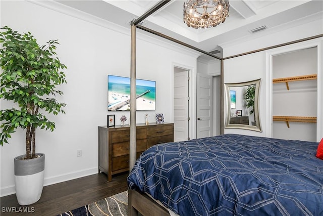 bedroom featuring visible vents, baseboards, dark wood finished floors, ornamental molding, and a notable chandelier