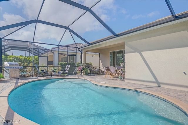 view of pool featuring a patio, glass enclosure, and a grill