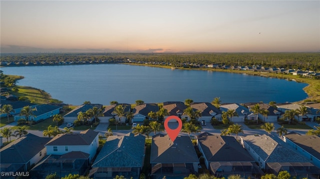 aerial view at dusk featuring a water view