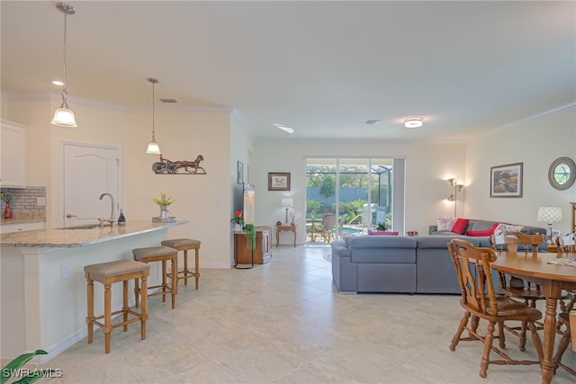 living room with crown molding and sink