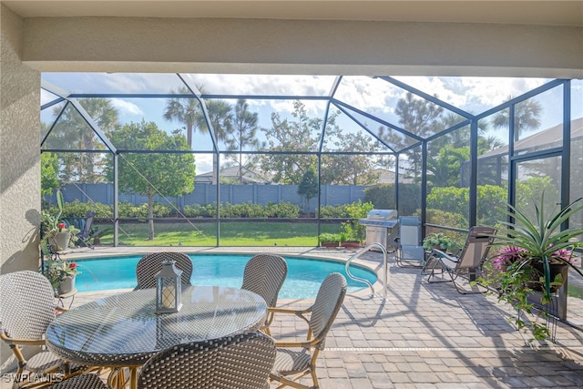 view of swimming pool with a lanai, a patio area, and grilling area