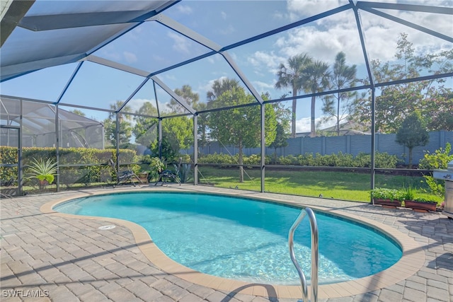 view of swimming pool featuring glass enclosure, a patio area, and a lawn