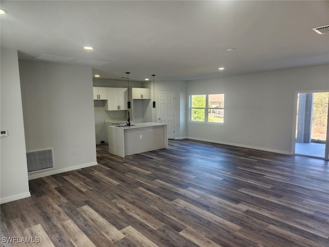 unfurnished living room with dark hardwood / wood-style flooring and sink