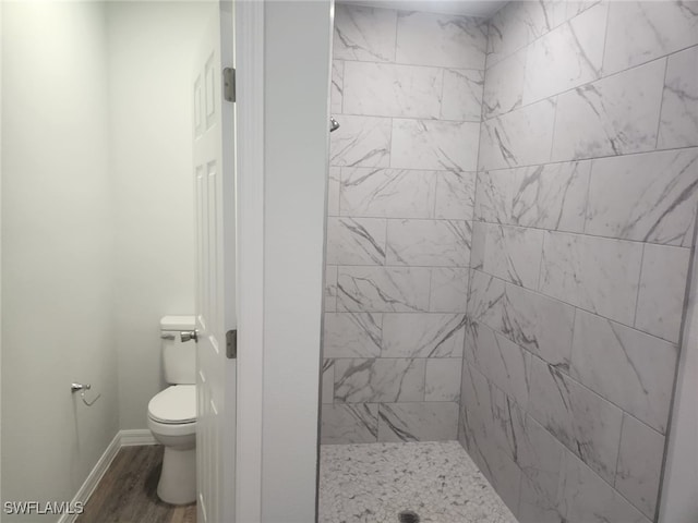 bathroom featuring toilet and a tile shower