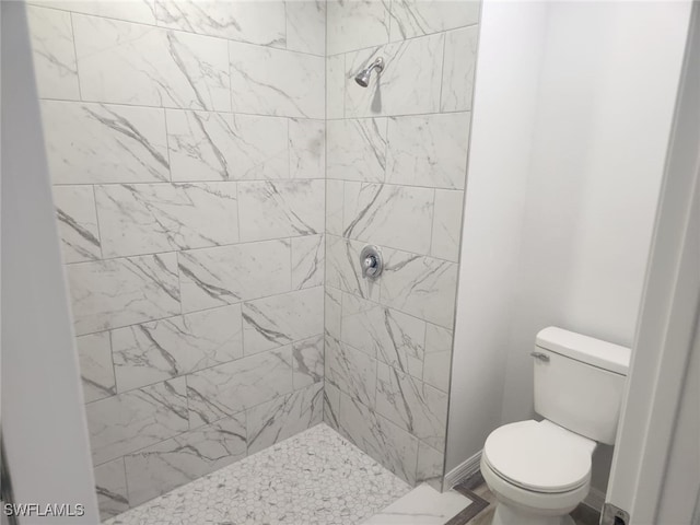 bathroom with tiled shower and toilet