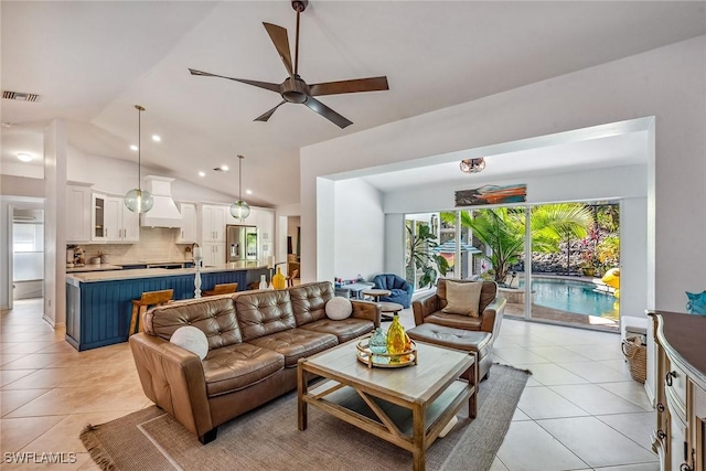 living room featuring light tile patterned floors, vaulted ceiling, and ceiling fan