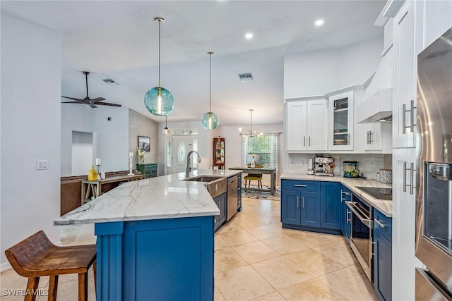 kitchen featuring a center island with sink, blue cabinets, ceiling fan, decorative light fixtures, and white cabinetry