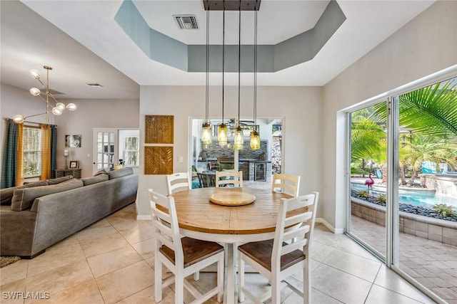 tiled dining room featuring a raised ceiling