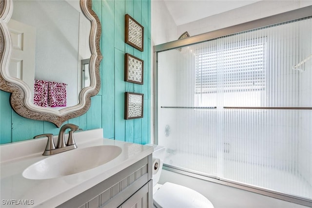 full bathroom with vanity, toilet, and bath / shower combo with glass door