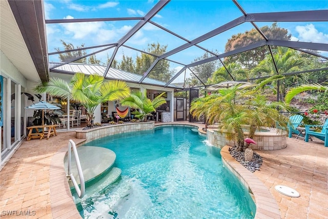 view of swimming pool with pool water feature, a patio area, and a lanai