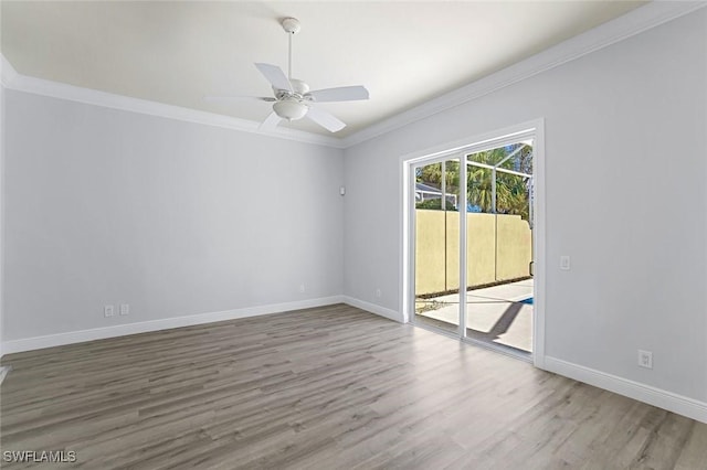 unfurnished room featuring baseboards, wood finished floors, and ornamental molding