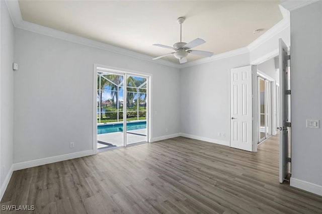 spare room with wood finished floors, baseboards, and ornamental molding