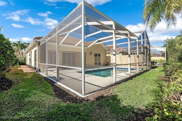 rear view of property with an outdoor pool, a yard, a patio, and glass enclosure