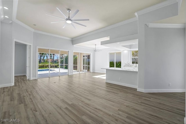 unfurnished living room featuring baseboards, wood finished floors, and a ceiling fan