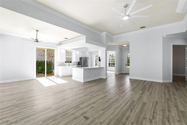 unfurnished living room featuring baseboards, light wood-style floors, ceiling fan, and ornamental molding