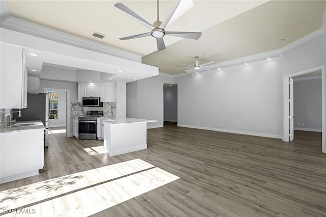 kitchen with visible vents, stainless steel appliances, white cabinets, crown molding, and open floor plan