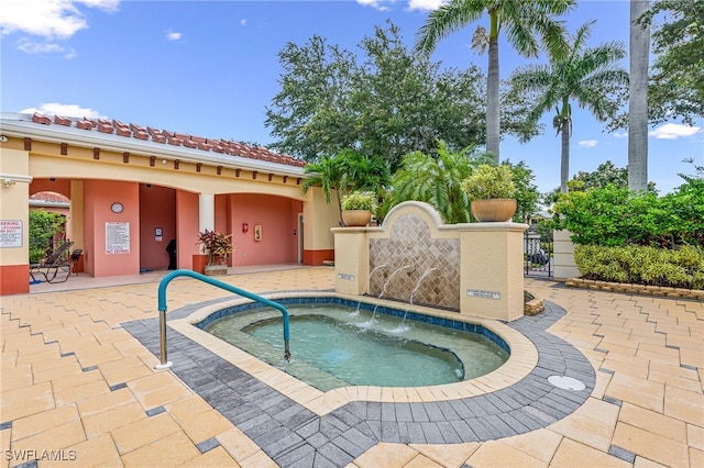 view of pool with a patio and a hot tub