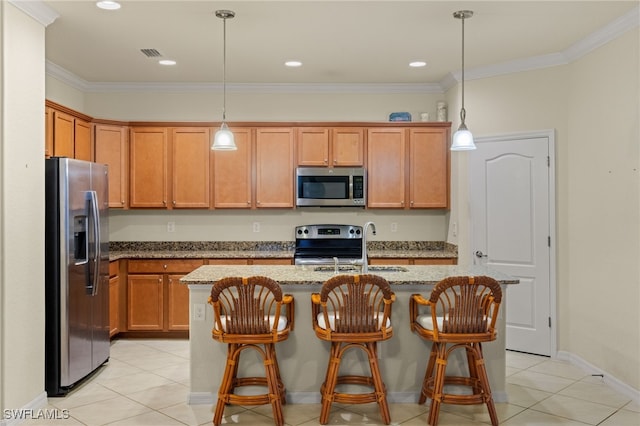 kitchen with light stone countertops, an island with sink, hanging light fixtures, and appliances with stainless steel finishes