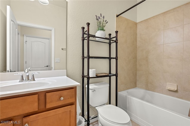 full bathroom featuring tiled shower / bath, vanity, and toilet