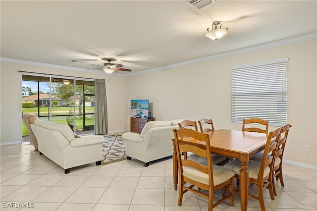 tiled dining room with a textured ceiling, ceiling fan, and crown molding