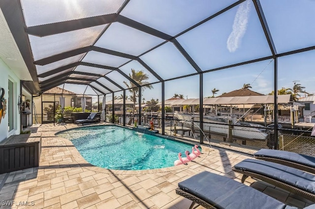 view of pool with a patio area, pool water feature, and glass enclosure