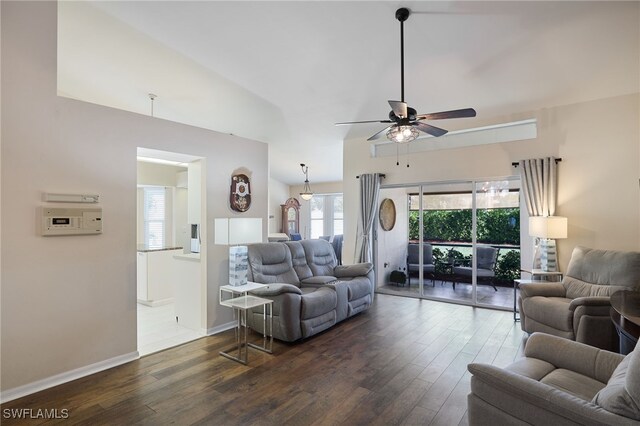 living room with ceiling fan, dark hardwood / wood-style flooring, and vaulted ceiling