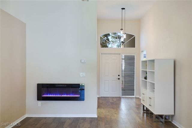 entrance foyer featuring dark hardwood / wood-style flooring, a high ceiling, and a notable chandelier