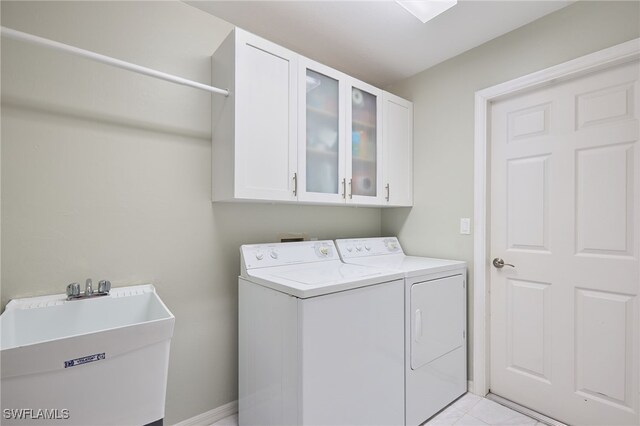 laundry area featuring washing machine and clothes dryer, sink, and cabinets