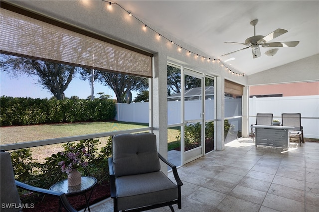 sunroom with ceiling fan and vaulted ceiling