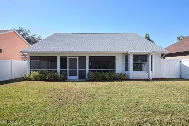 back of property featuring a sunroom and a yard