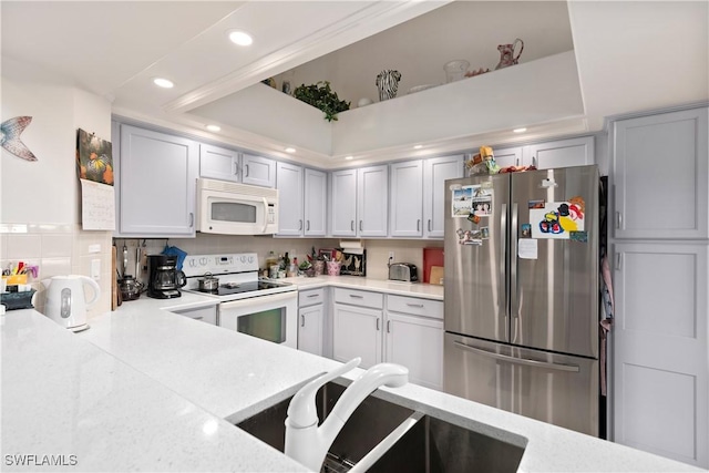 kitchen with white appliances, backsplash, ornamental molding, and sink