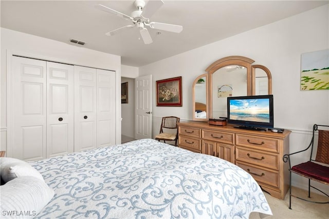 carpeted bedroom featuring ceiling fan and a closet