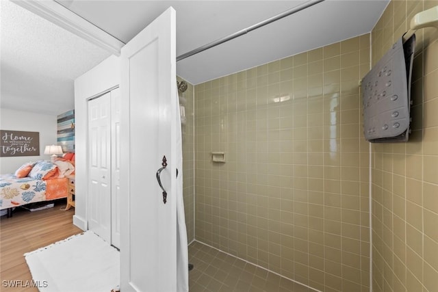 bathroom featuring a tile shower and hardwood / wood-style floors