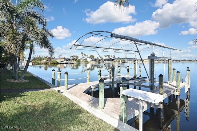 view of dock featuring a water view and a yard